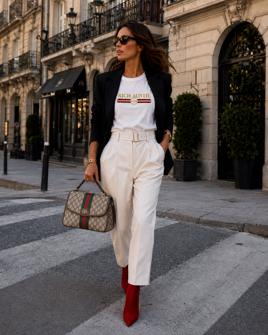 Woman wearing white G✦CCI inspired Rich Auntie Club tee with black blazer and cream trousers